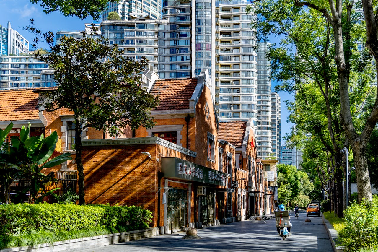 Street view of historic brick buildings alongside modern skyscrapers in an urban setting.